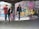 Three young men with skateboards are gathered in an urban environment filled with colorful graffiti. They stand on a concrete floor, and one of them is holding a bright pink skateboard. The walls and columns are covered in vibrant street art, creating a lively and edgy backdrop.