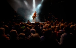 man playing guitar while performing on stage