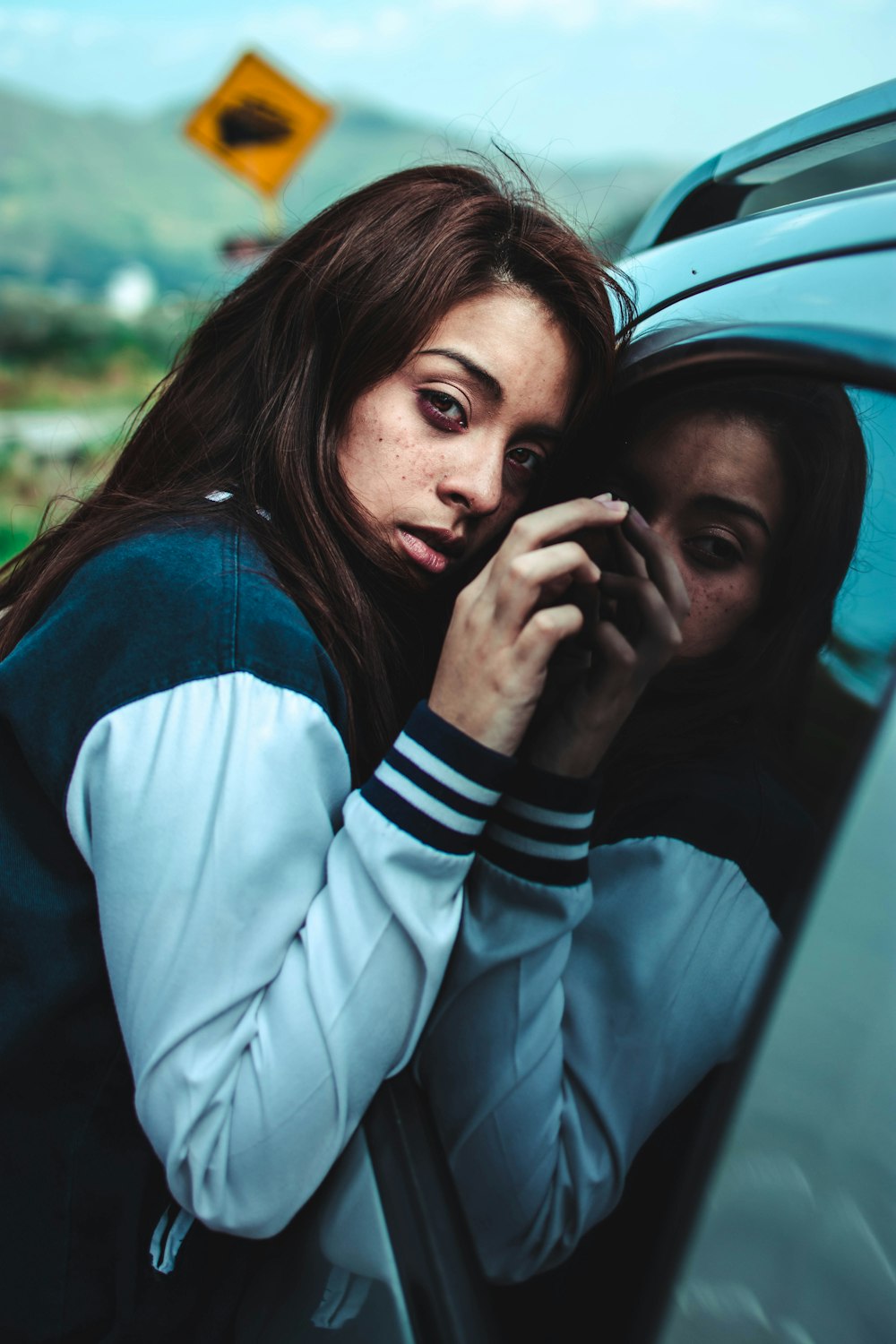 woman leaning in car mirror