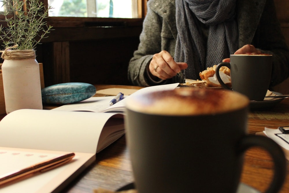 black coffee mug near person eating