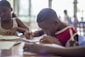 boy writing on printer paper near girl