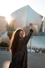 woman walking towards grey building