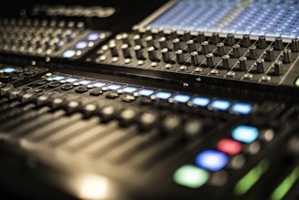 Close-up image of an analog mixing console with knobs and sliders.