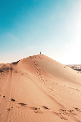 man standing on sand dune