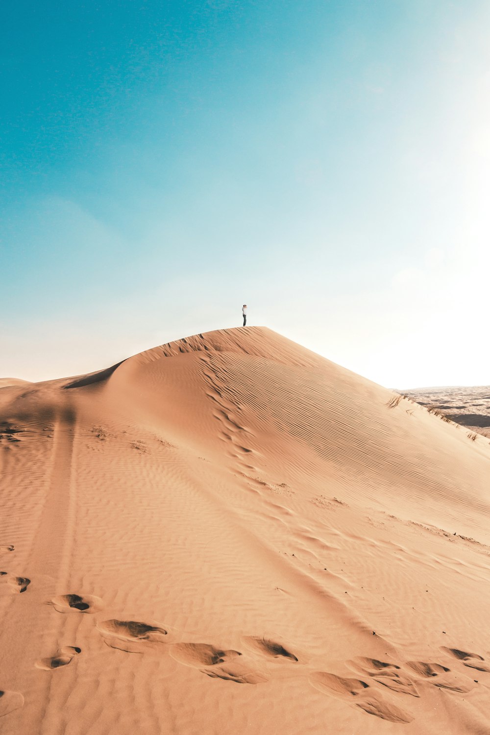 hombre de pie sobre la duna de arena