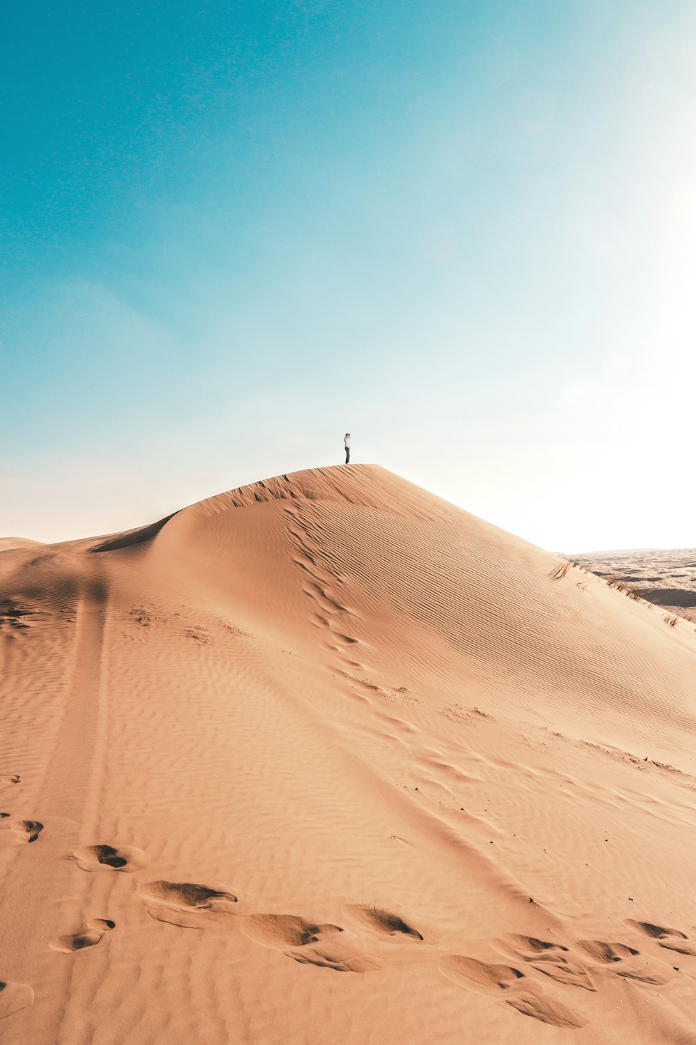 man standing on sand dune