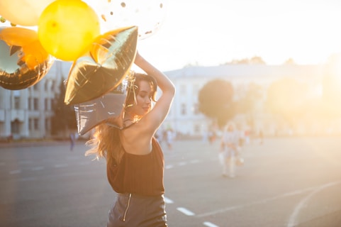 woman holding gold and silver foil balloons