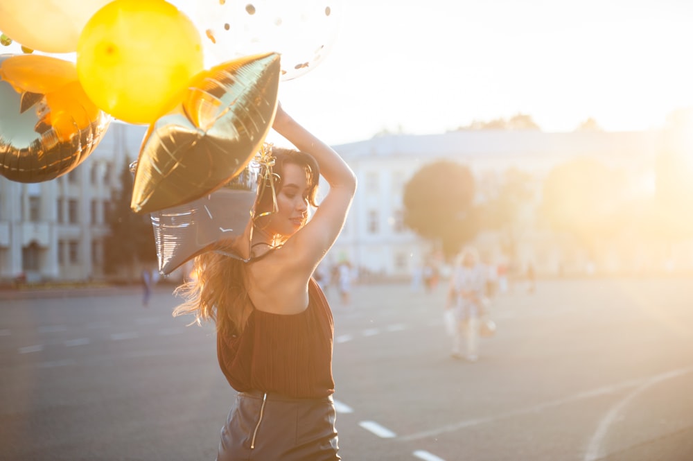 woman holding gold and silver foil balloons