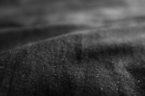 A close-up of premium fabric textures in dark and neutral tones.