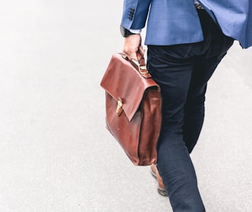 person walking holding brown leather bag