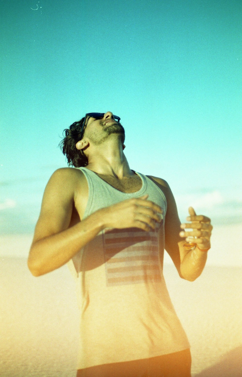 man wearing gray tank top and sunglasses