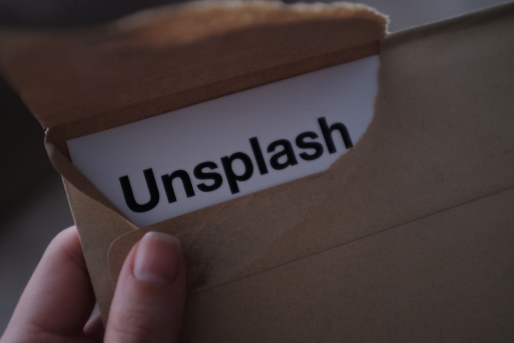 closeup photo of person holding brown envelope