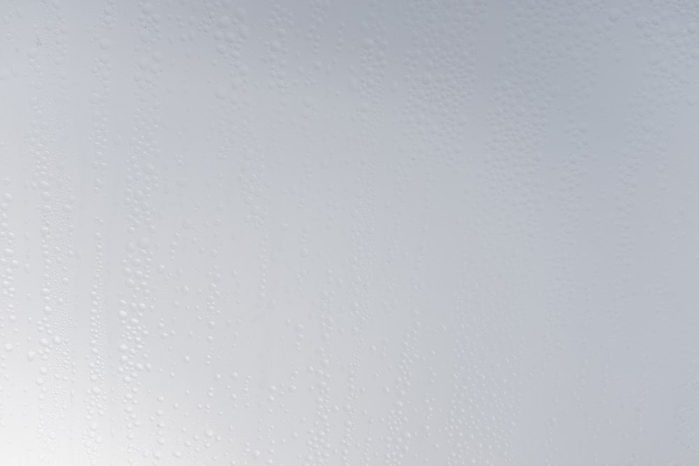 uma parede branca com gotas de água sobre ela