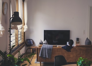 woman sitting on couch in front of LED TV