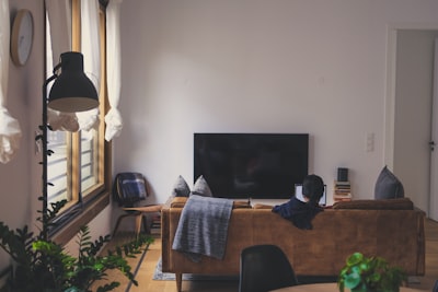 woman sitting on couch in front of led tv flat google meet background