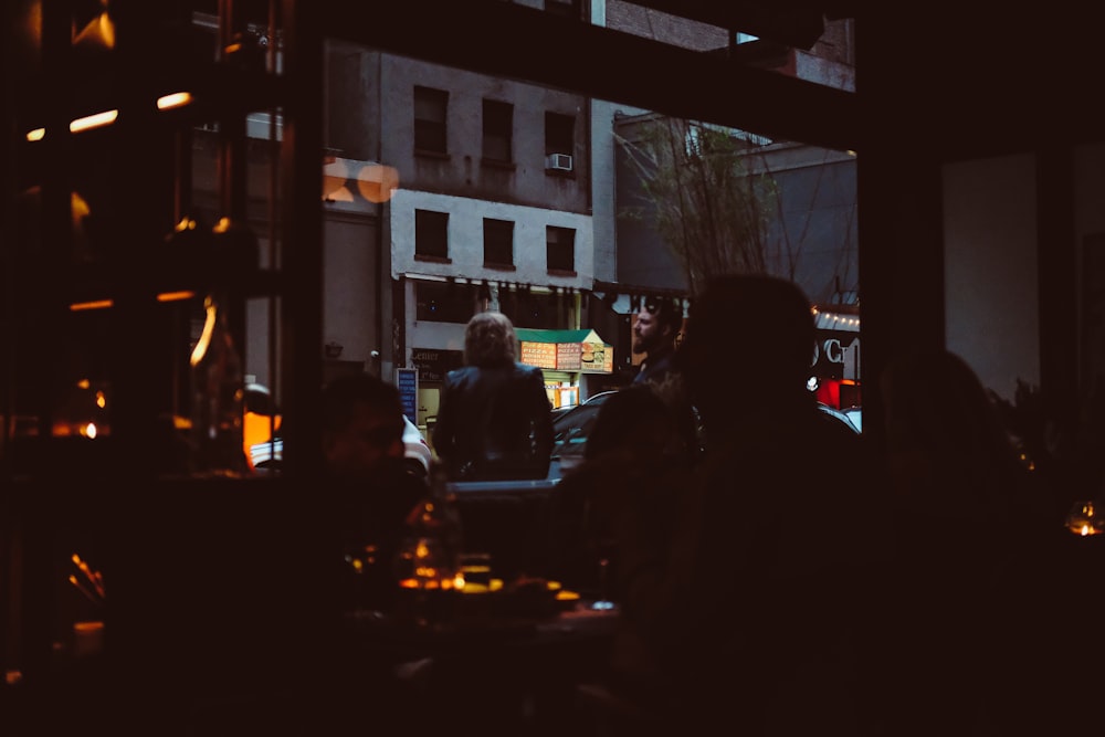 a group of people sitting at a table in a dark room