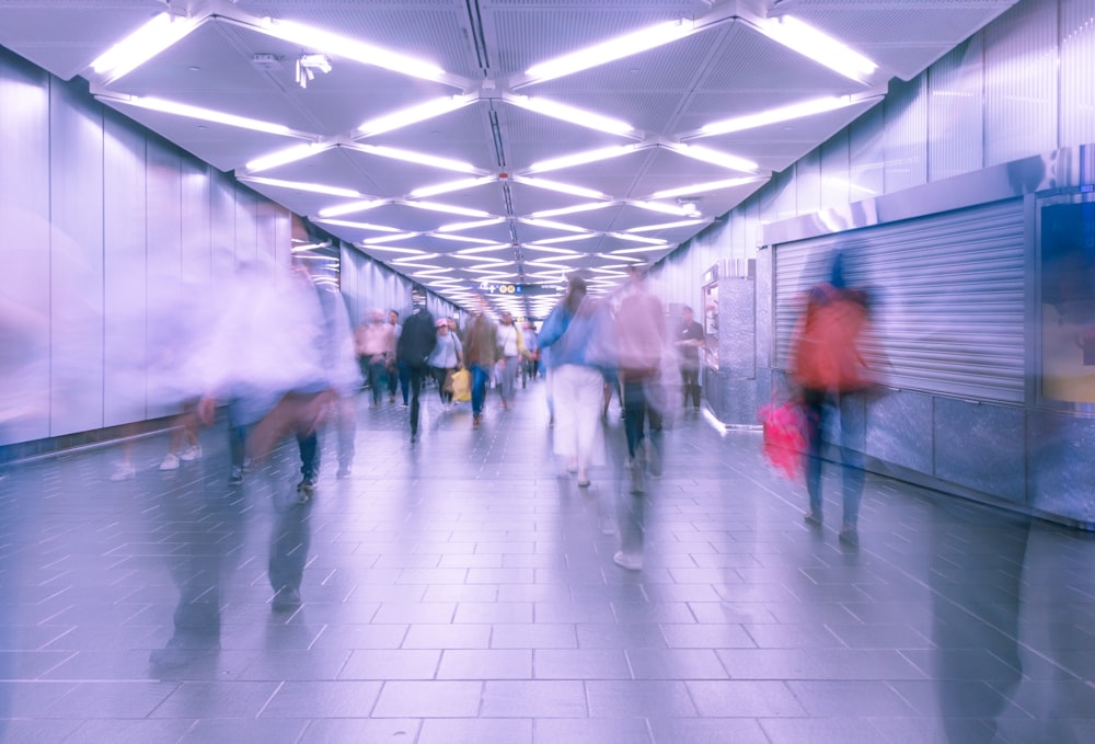 a group of people walking down a long hallway