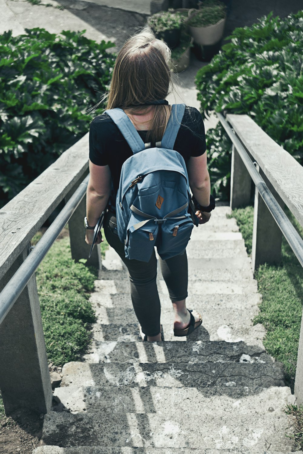 woman with backpack walking down on staircase