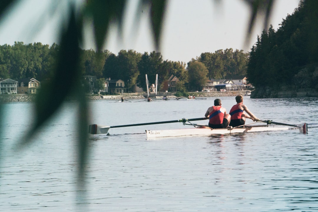 two men riding on boat on calm body of water