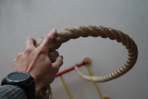 Close-up of hands gripping a colorful jump rope during a workout session.