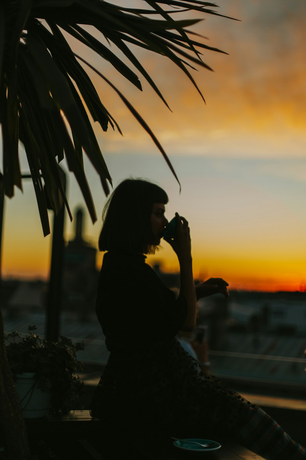 silhouette woman drinking from teacup during golden hour