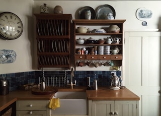 white kitchen cupboards and rack with dinnerware arranged on it