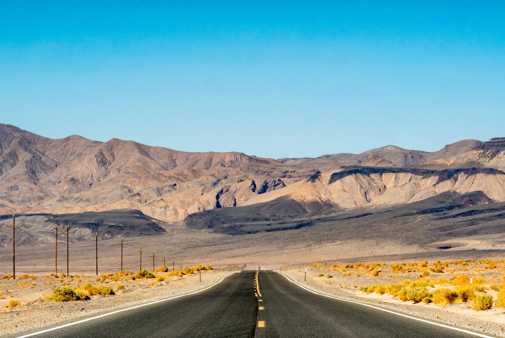 grey asphalt road near mountains