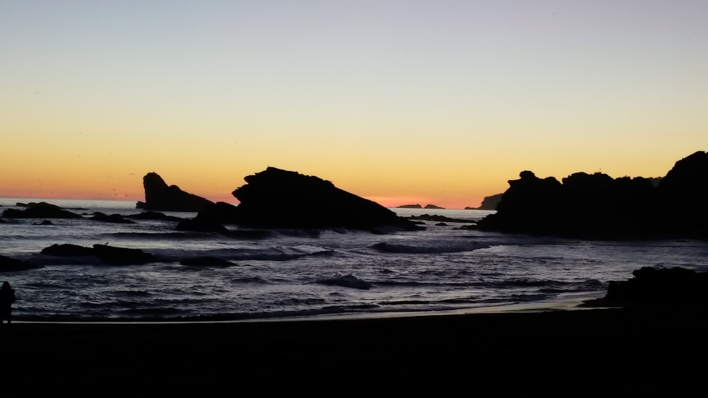 rocks covered with body of water during golden hour