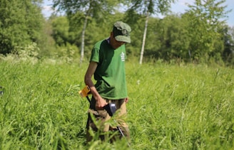 A technician inspecting equipment in a green field.