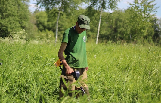 A farmer using a smartphone in a lush green field, monitoring environmental data.