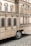A mobile structure mimics the facade of a classical building with detailed architectural elements such as windows, columns, and ornate features. It is mounted on wheels, indicating it can be transported, and rests on a cobblestone surface.