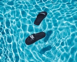 black Nike slide sandals on swimming pool