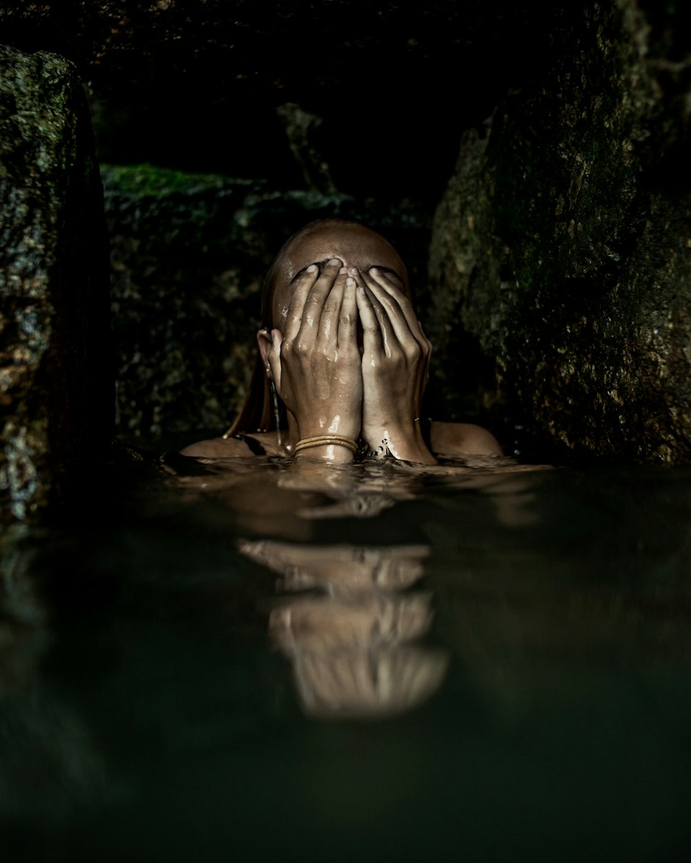 Frau auf dem Wasser, die ihr Gesicht mit beiden Händen bedeckt