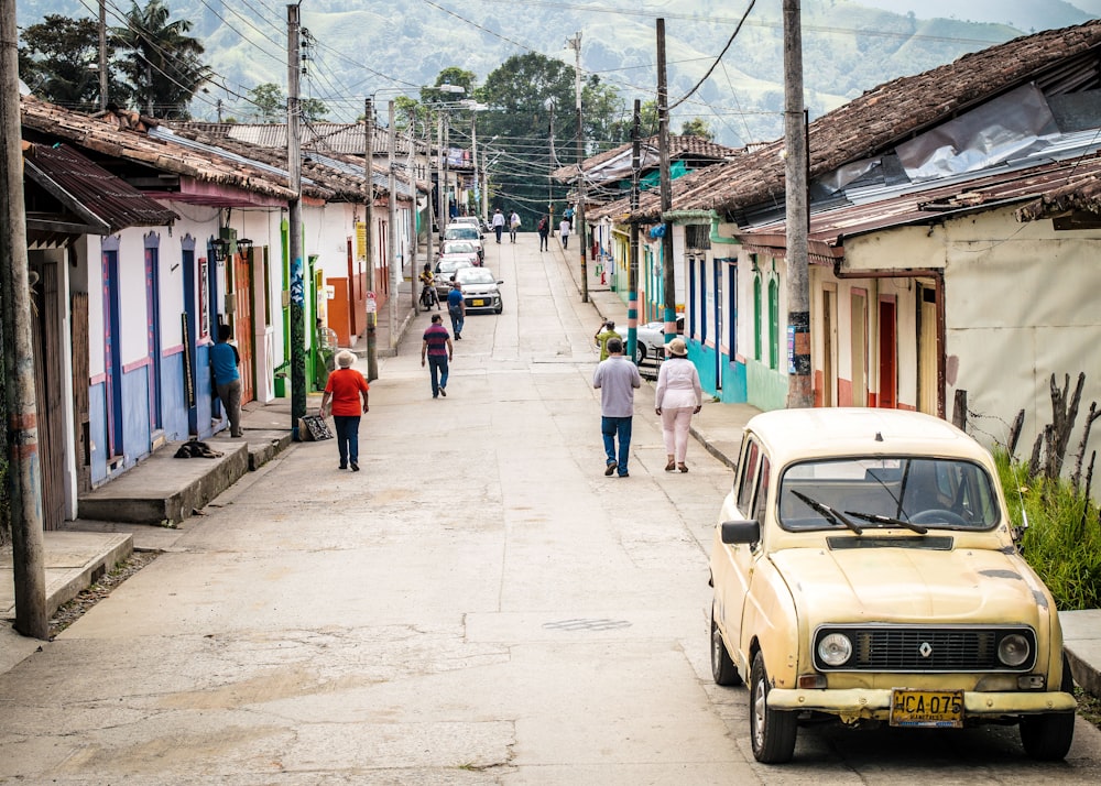 people walking on street near houses during daytime