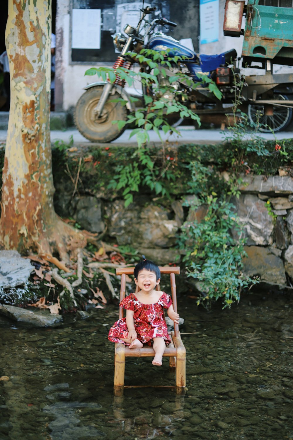 girl sitting on chair surrounded by body of water