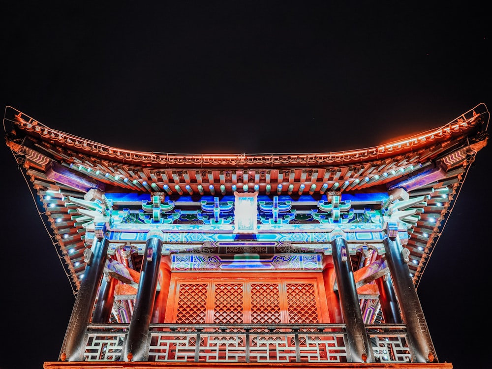 lighted orange and blue pagoda temple at night