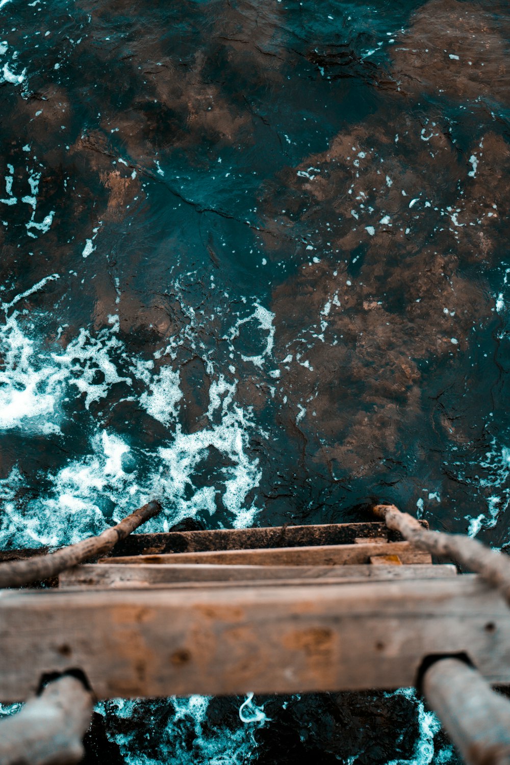 Fotografía de la vista superior de una escalera de madera marrón y un cuerpo de agua
