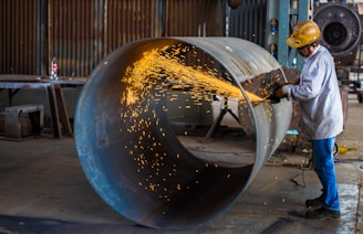 man wearing yellow hard hat holding angle grinder