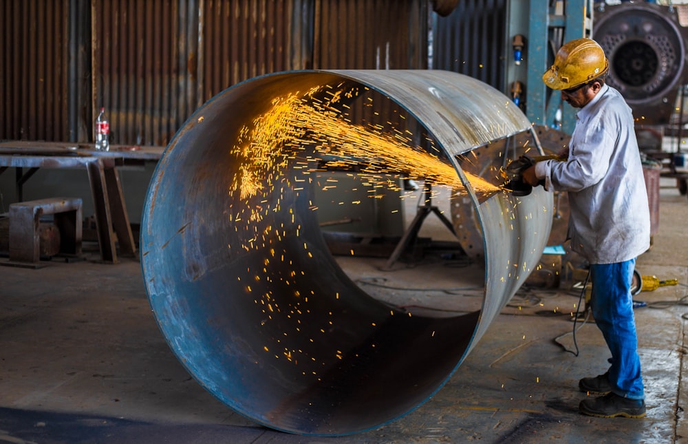 man wearing yellow hard hat holding angle grinder