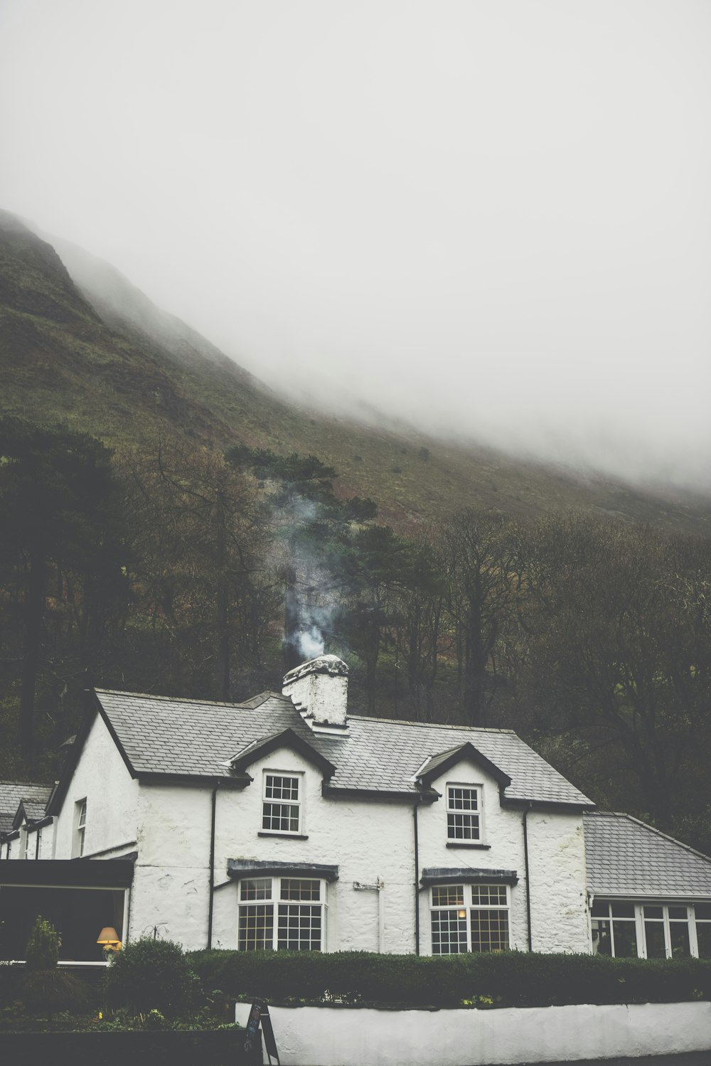 gray house with chimney near green mountain