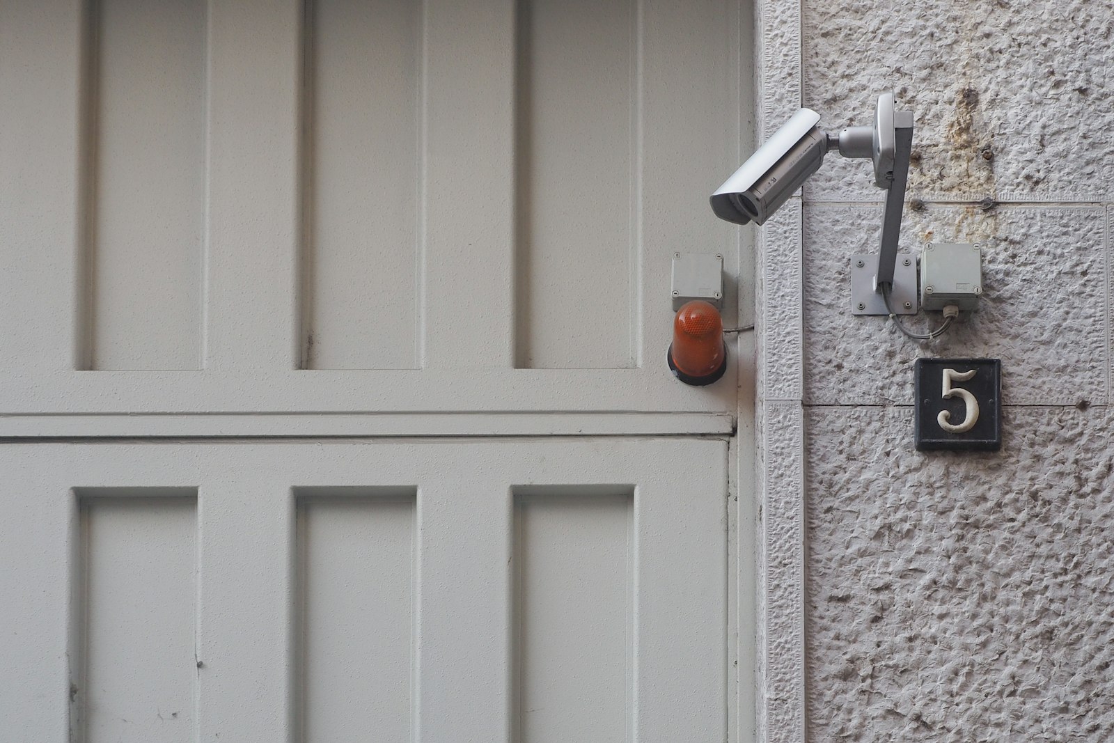 Front door with a mounted security camera and alarm light for home security