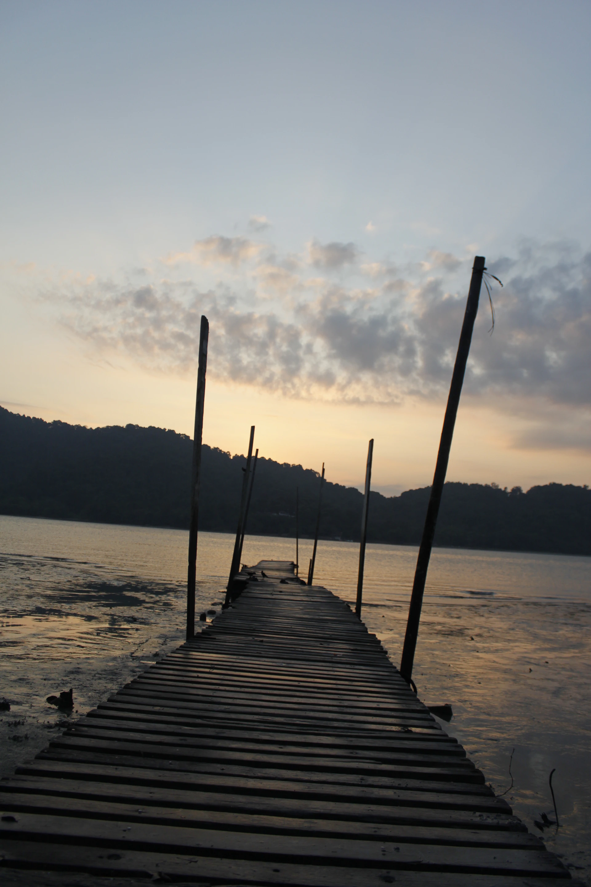 A quiet wooden dock stretching into calm waters under a pastel sunset sky, capturing the peaceful spirit of the Low Country.