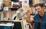 man beside white desk fan