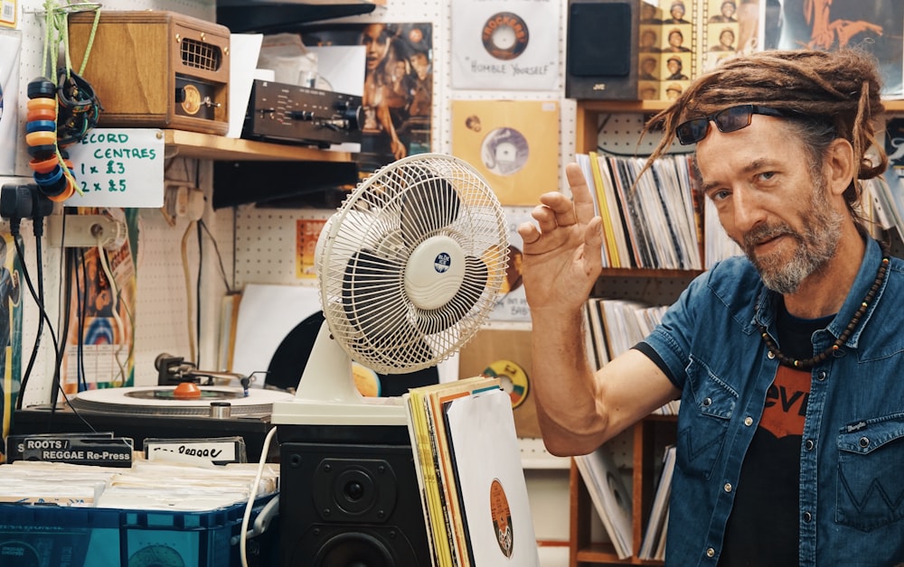 man beside white desk fan