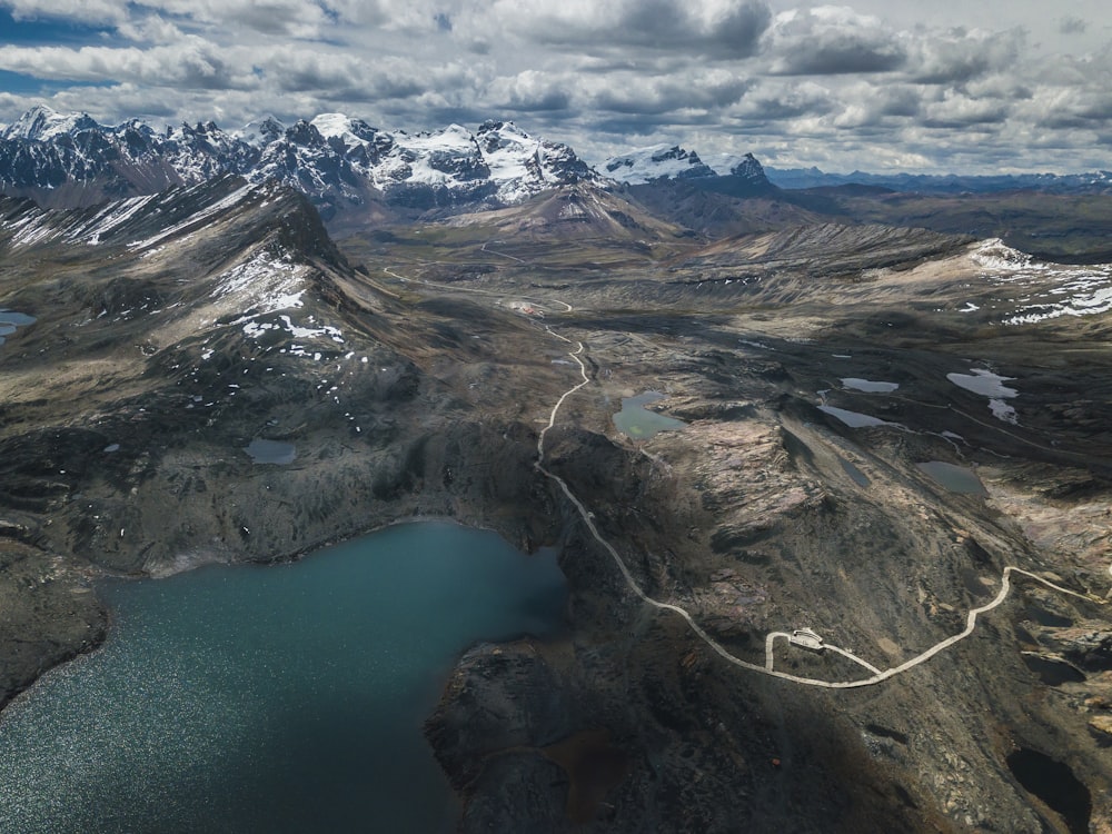 Fotografía aérea de un lago rodeado de montañas bajo el cielo nublado