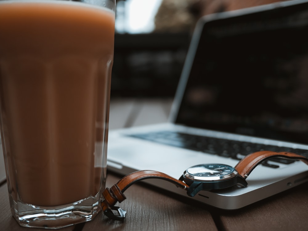 laptop computer beside drinking glass