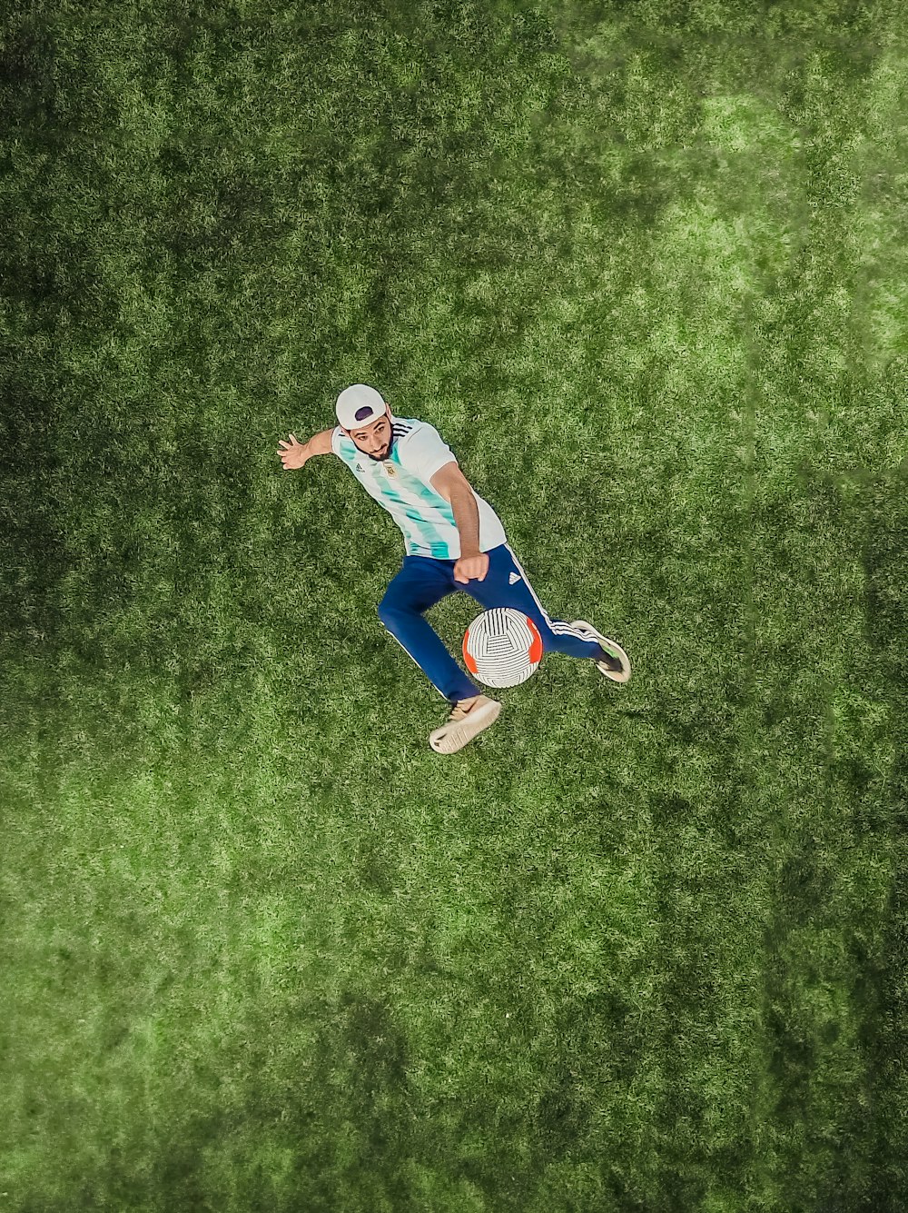 Vista aerea dell'uomo che gioca a pallone da calcio sull'erba