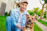 man sitting beside brown dog on green grass field