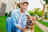 man sitting beside brown dog on green grass field