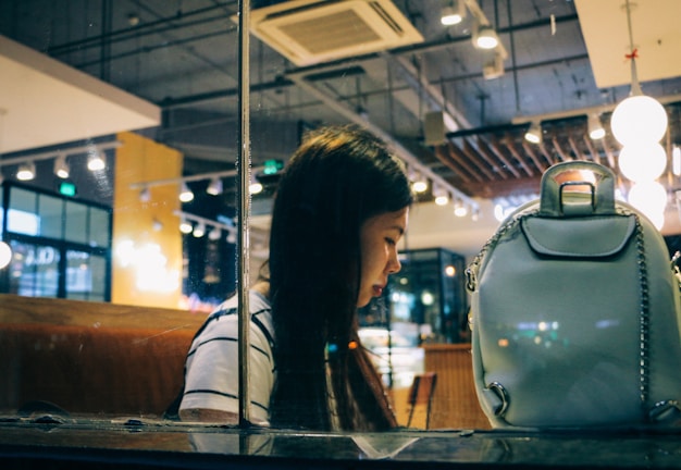 Young British woman using life butler app on smartphone to book travel in a cozy café